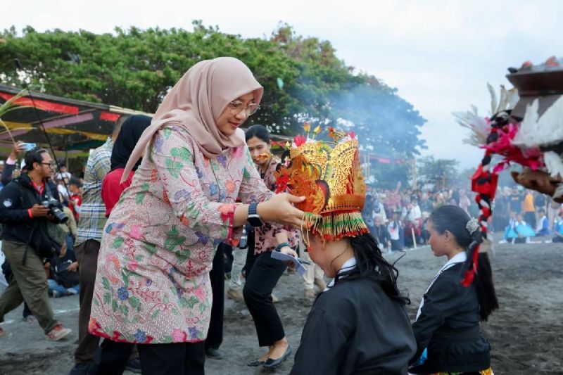Bupati Banyuwangi Ipuk Fiestiandani memasang oprog dalam tradisi ritual "Meras Gandrung" di Pantai Boom Banyuwangi, Jatim. Jumat (foto: gemapos/ antara)